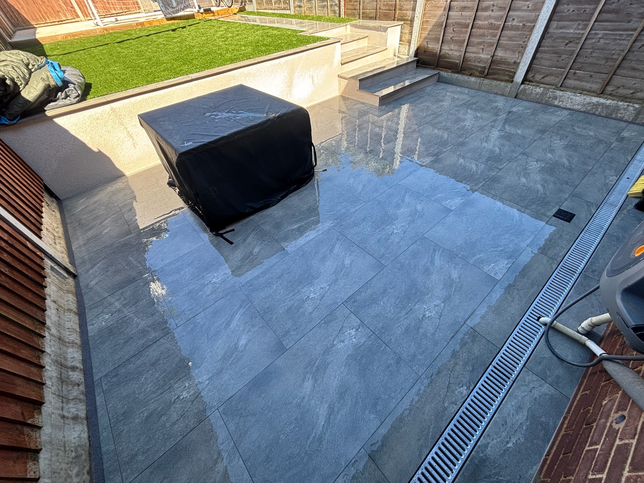 Earthcore Grey Porcelain Patio, Concrete Base, Artificial Grass & Rendered Wall finished photo 4