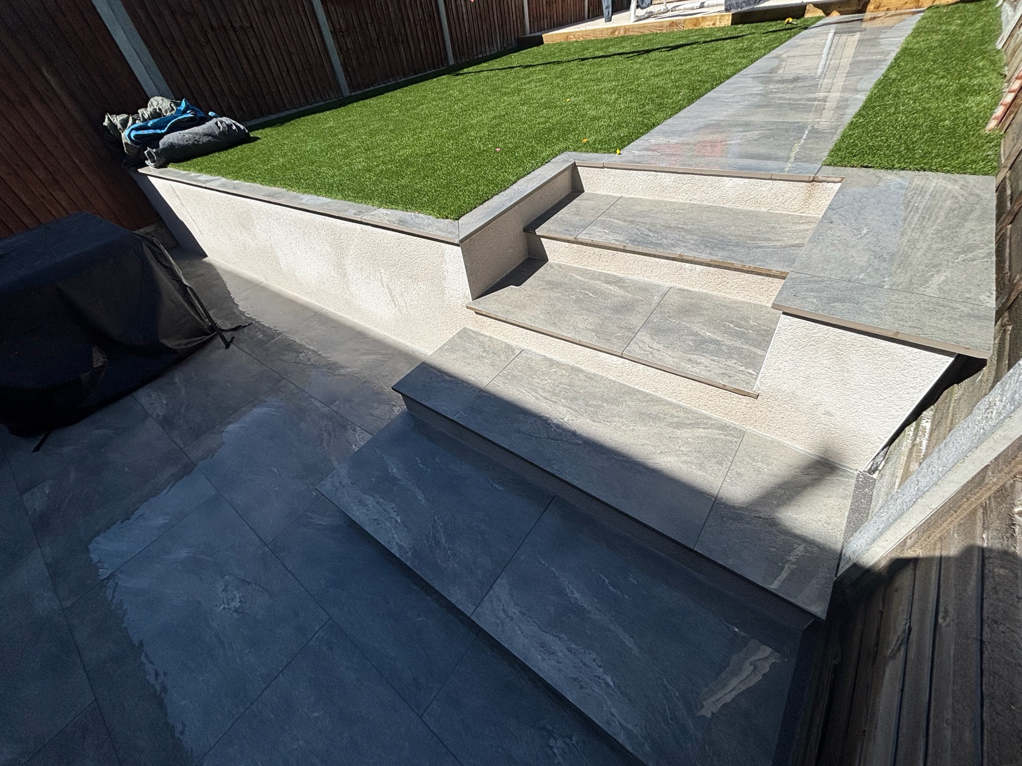 Earthcore Grey Porcelain Patio, Concrete Base, Artificial Grass & Rendered Wall finished photo 6